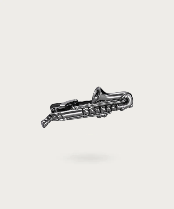 Pince de cravate en forme de saxophone noir, symbolisant la profondeur et le mystère du jazz.