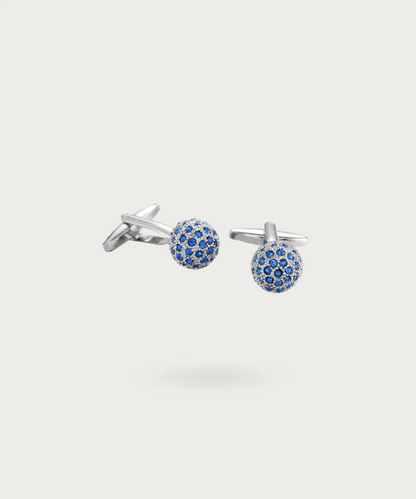 Boutons de manchette en forme de boule argenté avec brillants bleus, symbolisant l'essence de la noblesse.
