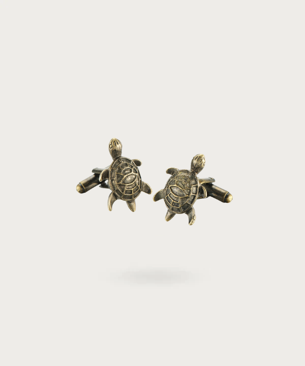 Boutons de manchette finement travaillés en forme de tortue de mer, symbolisant la sérénité et la sagesse.