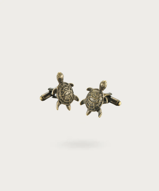 Boutons de manchette finement travaillés en forme de tortue de mer, symbolisant la sérénité et la sagesse.