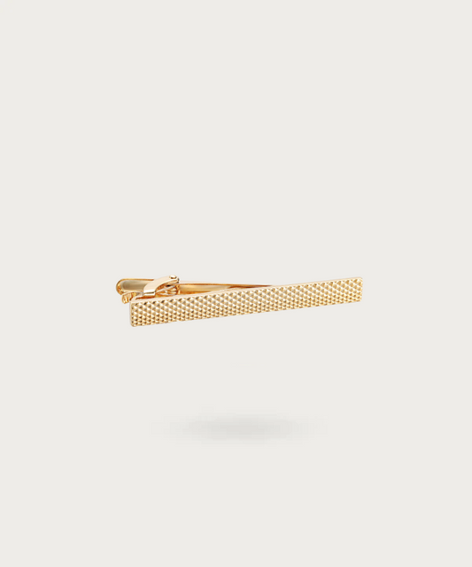 Pince à cravate lisse et épurée en finition dorée, symbolisant l'élégance simple et raffinée.