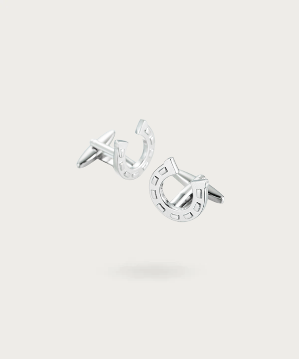 Boutons de manchette élégants en forme de fer à cheval, avec une finition argentée brillante et des détails sculptés avec précision.
